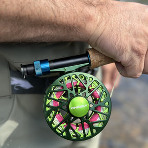 man holding fishigng rod with green burst fly reel