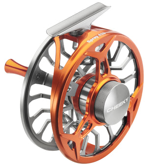 A Cheeky Spray 450 fly reel shown at an angle, featuring an orange aluminum frame, silver spool, and a textured silver drag knob with the Cheeky logo.
