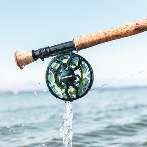Drip Fly fishing reel attached to a rod with water dripping from it over a body of water.