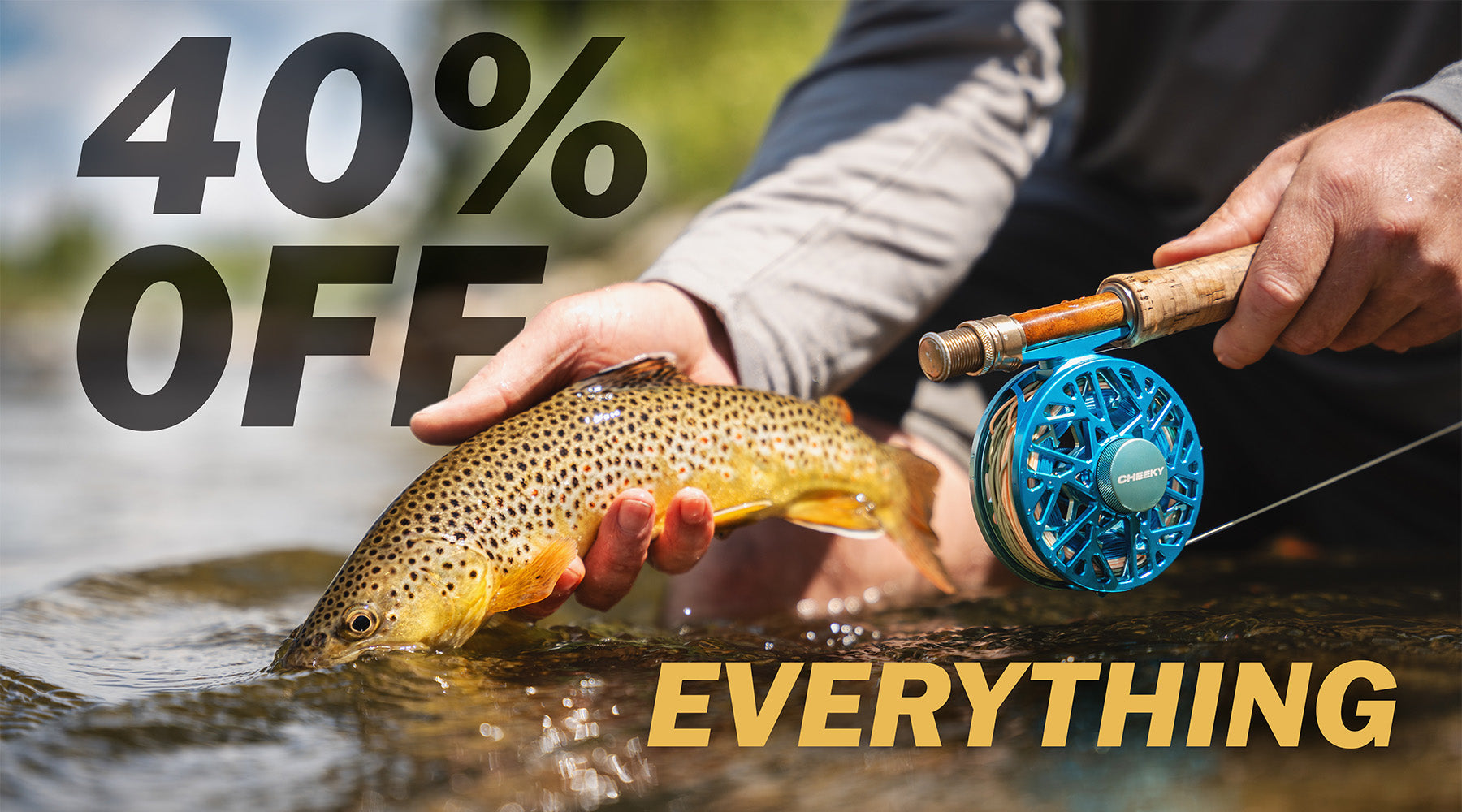 Person holding a fish and a fishing rod with promotional text overlay in an outdoor setting. The overlay text reads "40% OFF EVERYTHING"