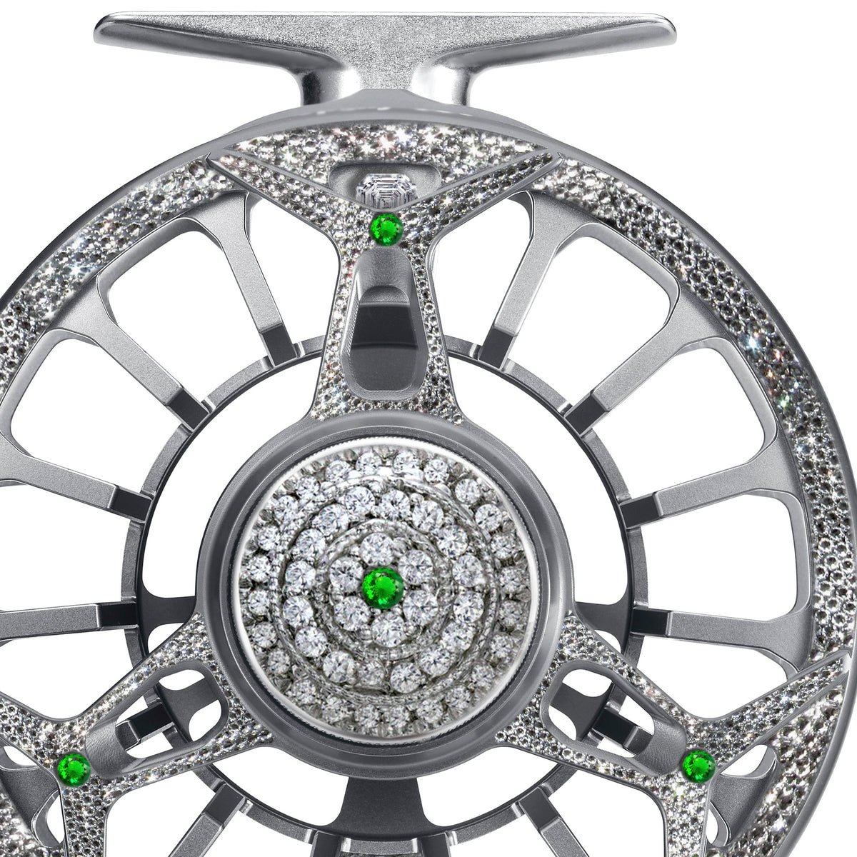 Close-up of the Diamond Drift fly reel featuring silver metalwork encrusted with diamonds and green gemstones.