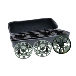 Two sage fly fishing spools and one drip fly reel displayed in front of an open gray and black protective case as the drip triple play.