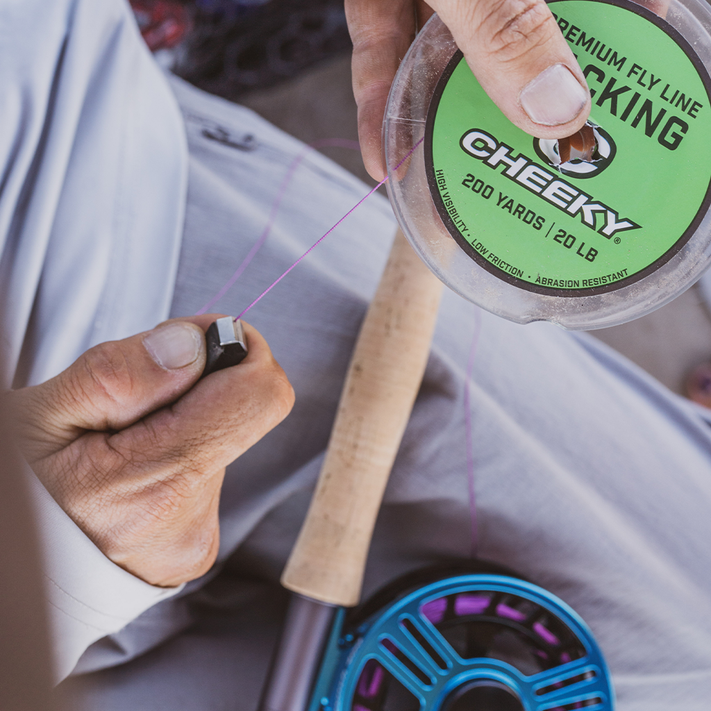 close shot of cheeky fishing purple backing being added to blue launch fly reel 