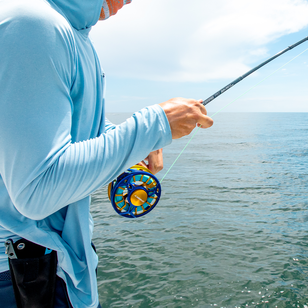 man fishing spray fly reel by cheeky fishing on ocean